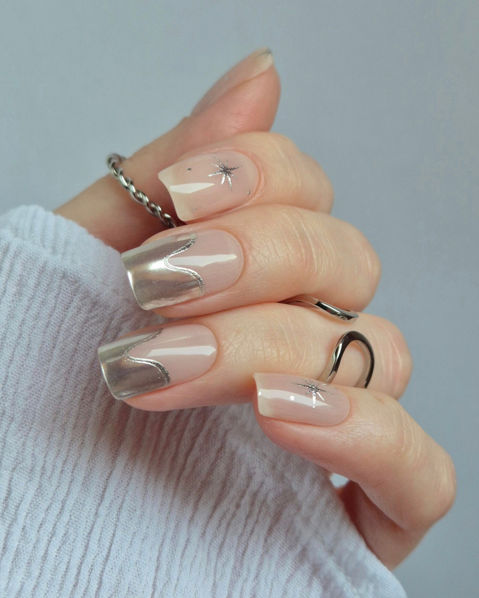 Sheesh Nails – Cosmic Crush – elegante Nagelfolien in transparentem Nude mit silbernem Glitzer und funkelnden Sternmotiven, stilvolles Design für moderne, glamouröse Maniküren. Perfekte Passform und glänzendes Finish für festliche Looks.