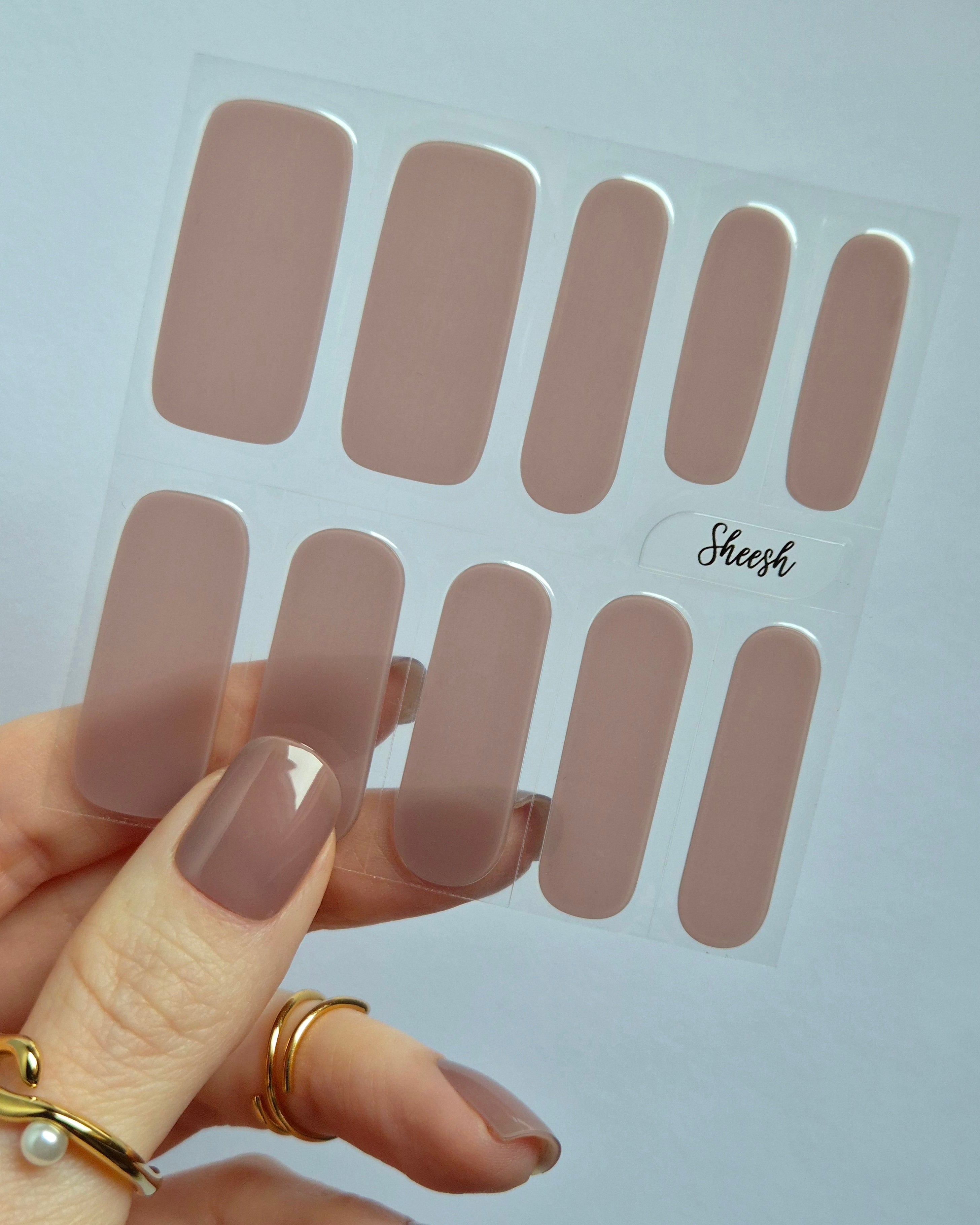 Sheesh UV-Nagelfolien Amelie – Detailaufnahme einer Hand mit Folienbogen der selbstklebenden Sheesh UV-Nagelfolien in Salonqualität.