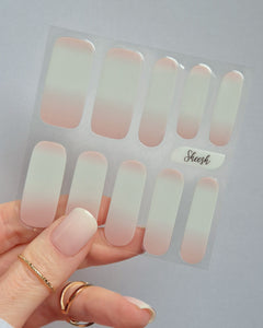Babyboomer UV-Nagelfolie mit zartem Ombré-Finish in Rosa-Weiß auf Hand vor hellem Hintergrund