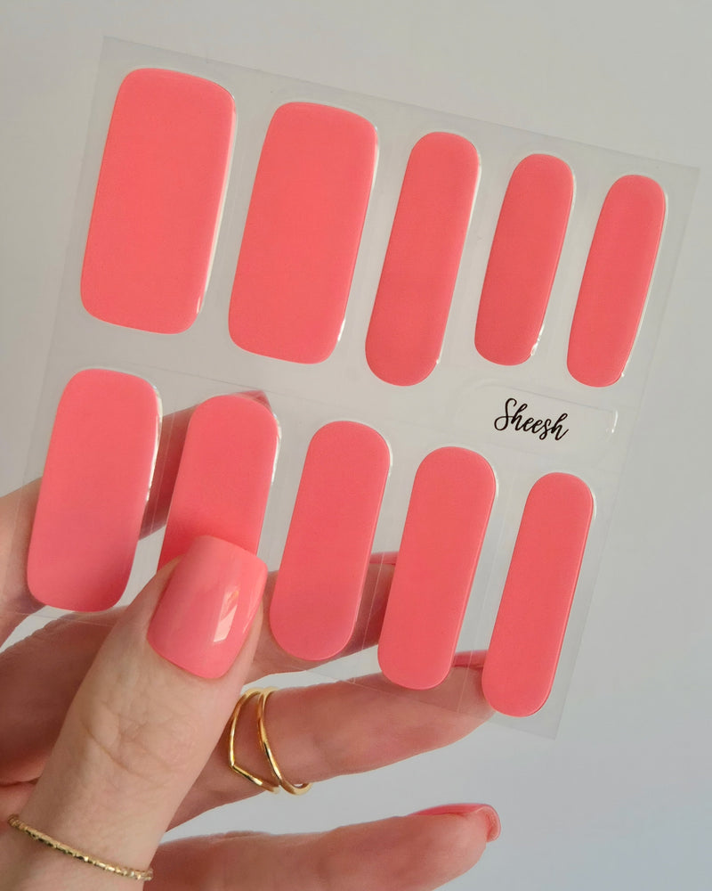 Leuchtend korallrosa UV-Nagelfolien mit glänzendem Finish auf Fingernägeln“