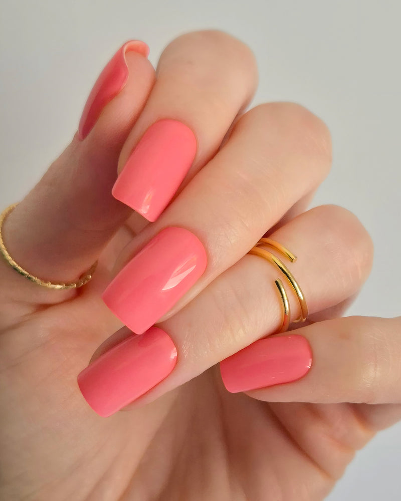 Leuchtend korallrosa UV-Nagelfolien mit glänzendem Finish auf Fingernägeln“