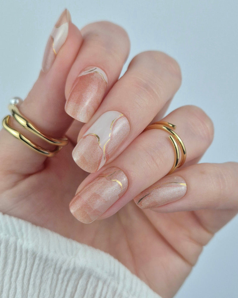 Sheesh Nails – Blossom Era – elegante Nagelfolien im zarten Marmor-Design mit goldschimmernden Akzenten. Perfekte Passform und langanhaltender Halt für feminine, luxuriöse Maniküren mit edlem Finish.