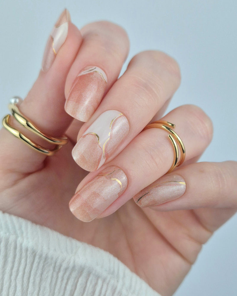 Sheesh Nails – Blossom Era – elegante Nagelfolien im zarten Marmor-Design mit goldschimmernden Akzenten. Perfekte Passform und langanhaltender Halt für feminine, luxuriöse Maniküren mit edlem Finish.
