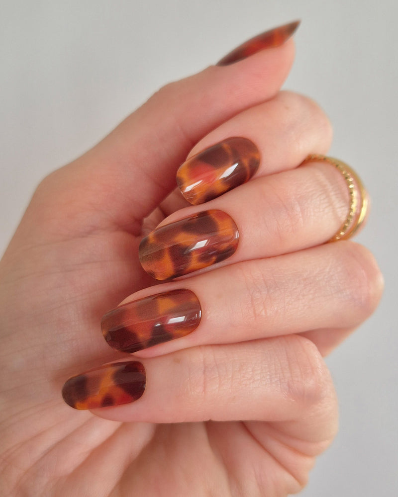 Sheesh Nails – Catwalk – stilvolle Nagelfolien in glänzendem Schildpatt-Design mit warmer Bernstein-Optik. Perfekte Passform und langanhaltender Halt für edle, ausdrucksstarke Maniküren mit luxuriösem Hochglanz-Finish.