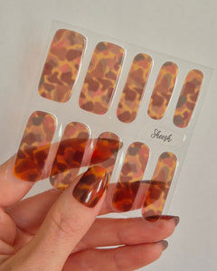 Sheesh Nails – Catwalk – stilvolle Nagelfolien im glänzenden Schildpatt-Design mit warmen Bernstein-Tönen. Perfekte Passform und starker Halt für edle, trendbewusste Maniküren mit luxuriösem Hochglanz-Finish.