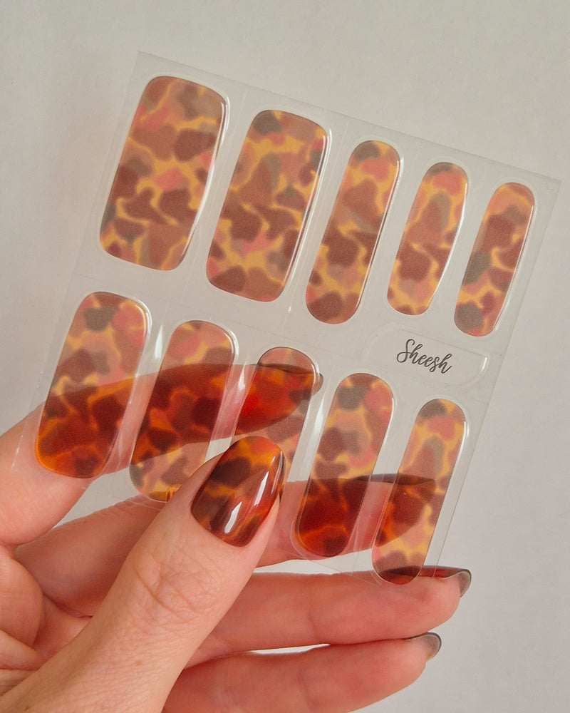 Sheesh Nails – Catwalk – stilvolle Nagelfolien in glänzendem Schildpatt-Design mit warmer Bernstein-Optik. Perfekte Passform und langanhaltender Halt für edle, ausdrucksstarke Maniküren mit luxuriösem Hochglanz-Finish.