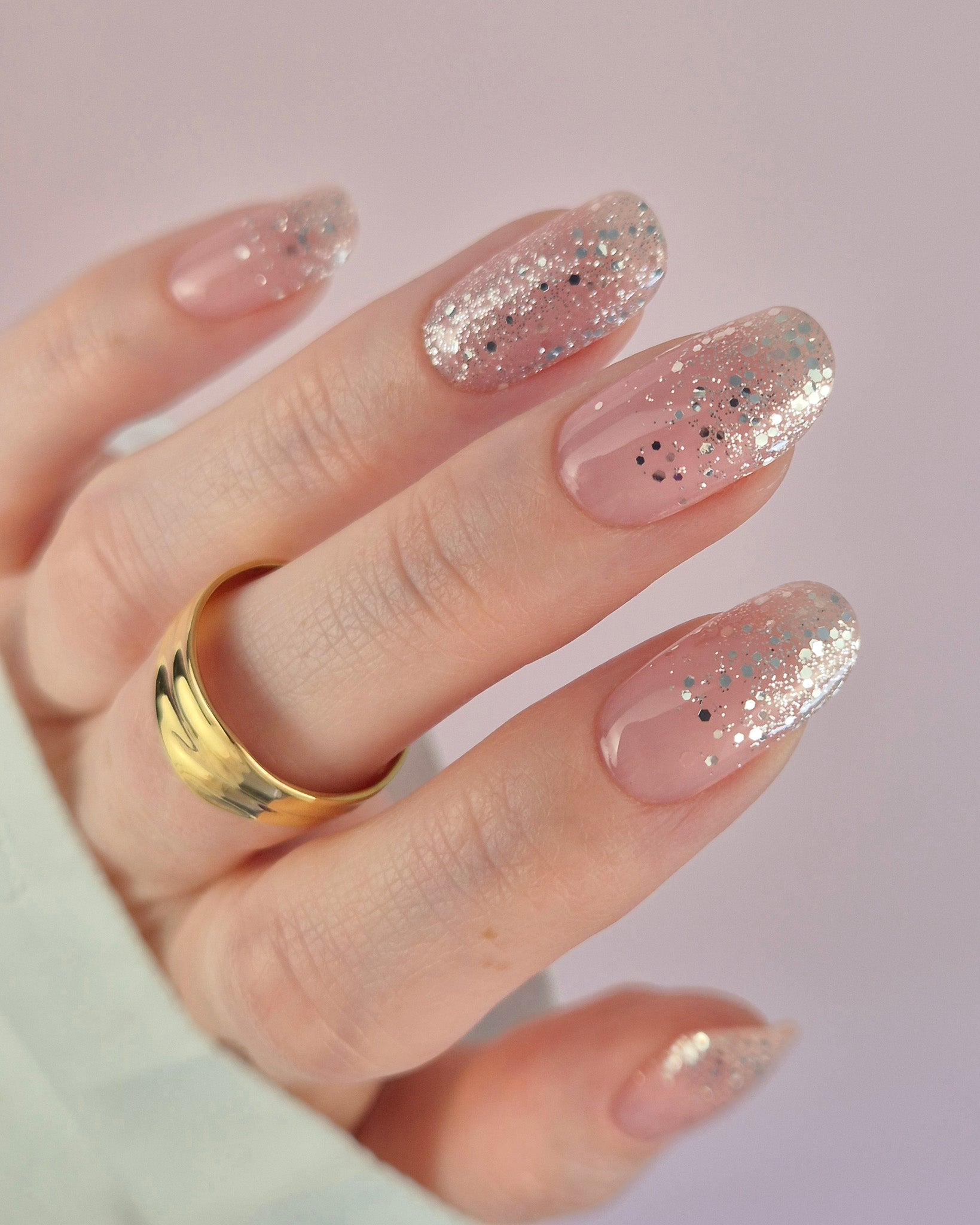 Nahaufnahme einer Hand mit der Sheesh Nails UV-Nagelfolie „Champagne Fizz“. Die Nägel zeigen ein zartes Nude-Rosa, das sanft in funkelnden Silberglitter übergeht. Der Look wirkt edel, festlich und feminin – perfekt für elegante Anlässe, festliche Looks oder einen stilvollen Alltagsglanz.