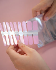 Sheesh Nails Kinder-Nagelfolien in Rosa – Kind öffnet Verpackung mit selbstklebenden Nagelfolien, einfache kinderfreundliche Anwendung ohne UV-Lampe für kreative Maniküre zuhause.