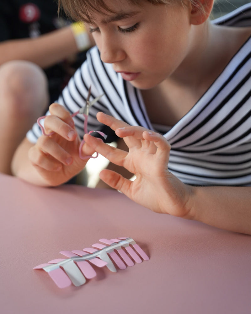 Sheesh Nails Kinder-Nagelfolien in Rosa – Mädchen schneidet selbstklebende Nagelfolien zurecht, kinderleichte Anwendung ohne UV-Lampe für eine kreative Maniküre zuhause.