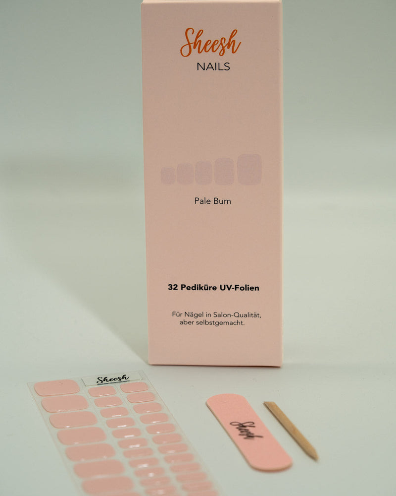 Sheesh Nails Pediküre UV-Folien „Pale Bum“ in zartem Rosé. Verpackung mit 32 UV-Folien, Nagelfeile und Holzstäbchen auf weißem Hintergrund. Für eine elegante Pediküre in Salon-Qualität – einfach selbstgemacht mit UV-Lampe.