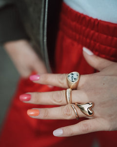 Hand mit mehrfarbiger Maniküre in Pink, Orange und Nude-Tönen, geschmückt mit goldenen Ringen. Die Nägel zeigen die Sheesh Nails Nagelfolien „Farben“ – ein trendiger, sommerlicher Look mit glänzendem Finish, ideal für kreative Nailart und modische Akzente.