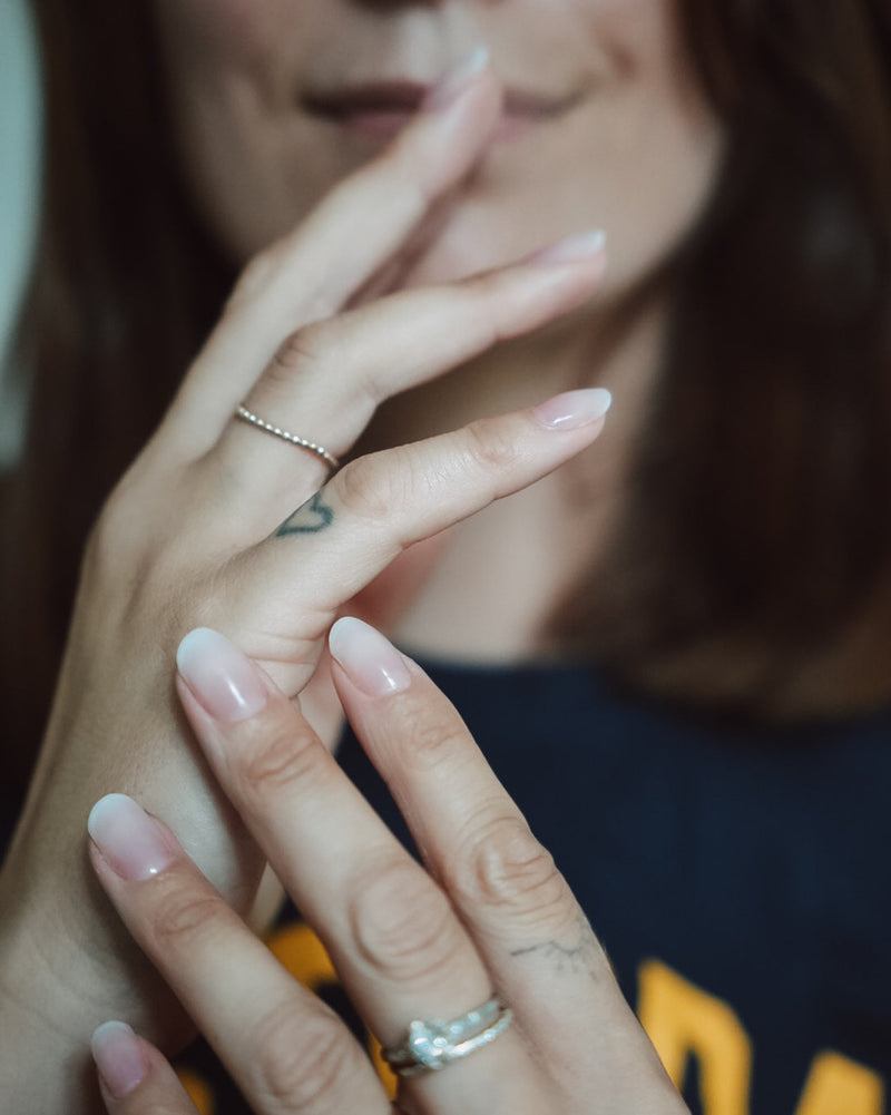 Hand mit elegantem, natürlichem French-Maniküre-Look und dezent roséfarbenen Spitzen. Die Nägel tragen die Sheesh Nails UV-Nagelfolie „French Kiss“ – ein klassischer, zeitloser Stil mit glänzendem Finish für gepflegte Hände und ein edles Erscheinungsbild.