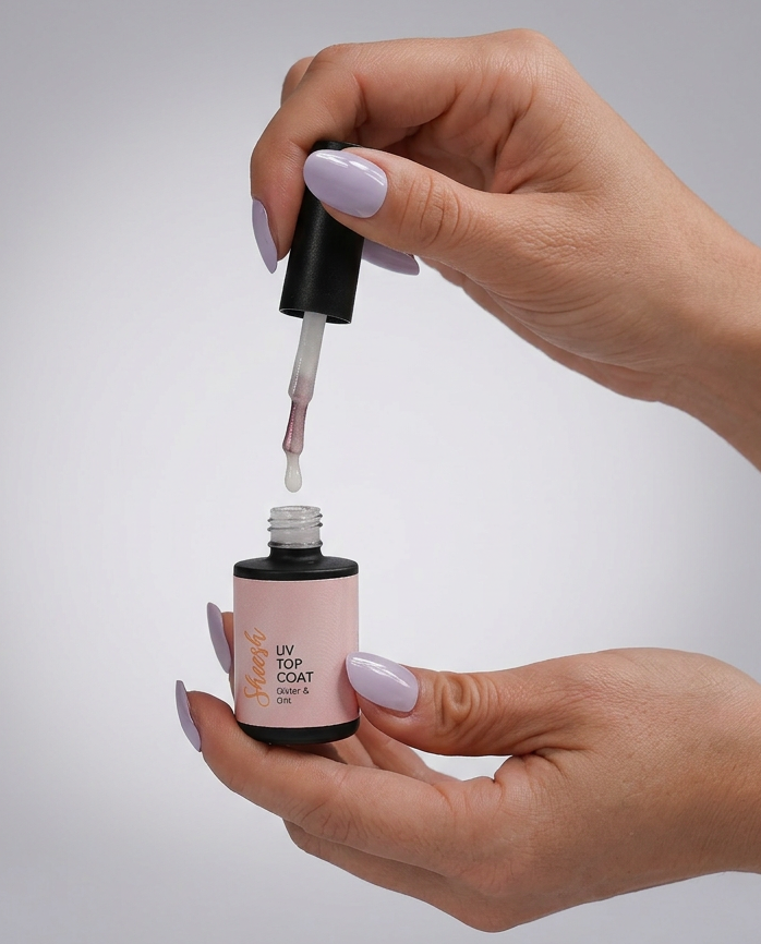 Sheesh Nails Top Coat Glitter & Grit in geöffneter Flasche mit Pinselapplikator in der Hand vor hellem Hintergrund