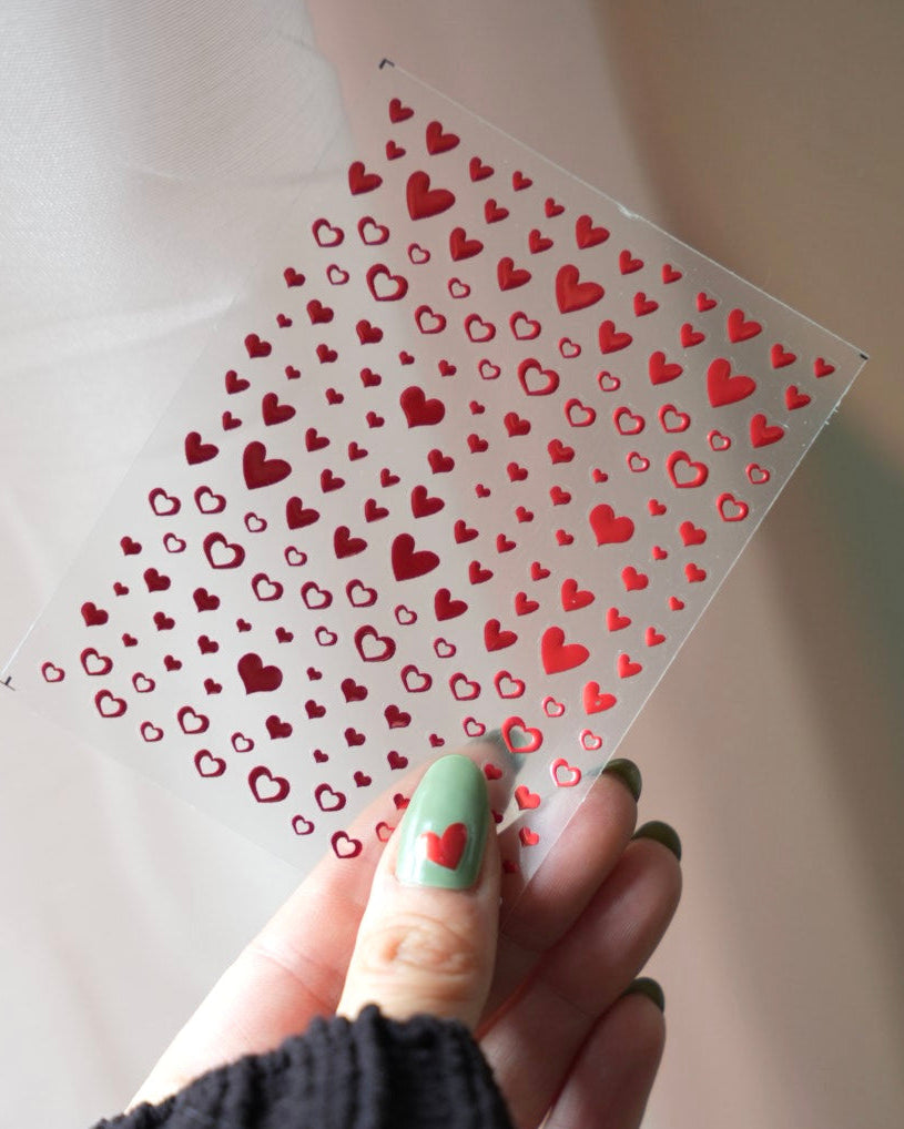 Stickerbogen mit roten Herz-Nagelstickern in verschiedenen Größen für Nail Art, perfekt als Akzent auf UV-Nagelfolien und Maniküre