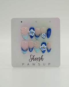 Sheesh Nails x PawsUp Press-on Nails – Set in Blau, Nude und Hellblau mit 3D-Blüten und Goldakzenten. Hochwertige, wiederverwendbare künstliche Fingernägel im eleganten Design mit Glanzfinish. Handgefertigte Press-ons für professionelle Maniküre zu Hause, modernes Nageldesign mit floralen Details.