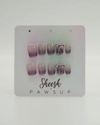 Sheesh Nails x PawsUp Press-on Nails in zartem Flieder- und Nude-Verlauf mit Schleifen-Detail. Hochwertige, wiederverwendbare künstliche Fingernägel im modernen Ombre-Design. Edles Press-on-Set für elegante Maniküre mit femininer Note und sanftem Farbspiel.