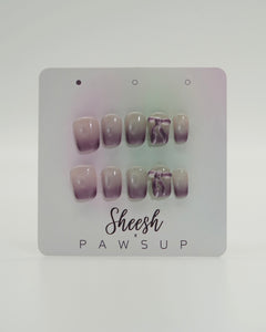 Sheesh Nails x PawsUp Press-on Nails in zartem Flieder- und Nude-Verlauf mit Schleifen-Detail. Hochwertige, wiederverwendbare künstliche Fingernägel im modernen Ombre-Design. Edles Press-on-Set für elegante Maniküre mit femininer Note und sanftem Farbspiel.