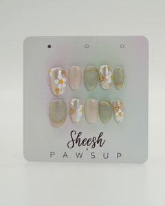 Sheesh Nails x PawsUp Press-on Nails in Grün, Nude und Weiß mit goldenen Details und floralen Mustern. Hochwertige, wiederverwendbare künstliche Fingernägel im eleganten Frühlingsdesign mit Glitzer und Blüten. Edles Press-on-Set für gepflegte Hände – stilvolles Nageldesign mit natürlichem Glamour.