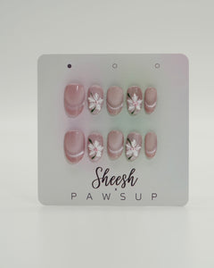 Sheesh Nails x PawsUp Press-on Nails in Rosé mit weißen Blüten und feinem Glitzerverlauf. Hochwertige, wiederverwendbare künstliche Fingernägel im zarten, femininen Design. Handgefertigtes Press-on-Set für elegante Maniküre mit floralen Details – perfekte Kombination aus Natürlichkeit und Glamour.