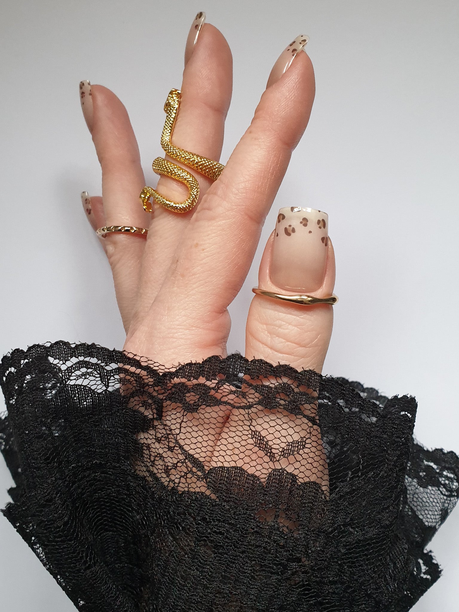 Hand trägt die Sheesh Nails UV-Nagelfolie Half Life. Die Folien zeigen ein transparentes Design mit feinem Leopardenmuster in Braun- und Beigetönen auf zartem Nude-Hintergrund. Der Look wirkt elegant, modern und leicht verspielt – perfekt für trendige Animal-Print-Maniküren mit stilvollem Finish.