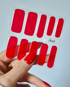 Hand mit leuchtend roten Nägeln trägt die Sheesh Nails UV-Nagelfolie „Lifeguard“. Der kräftige, hochglänzende Rotton sorgt für einen ausdrucksstarken, klassischen Look – perfekt für selbstbewusste Styles, Sommer-Outfits und elegante Auftritte.