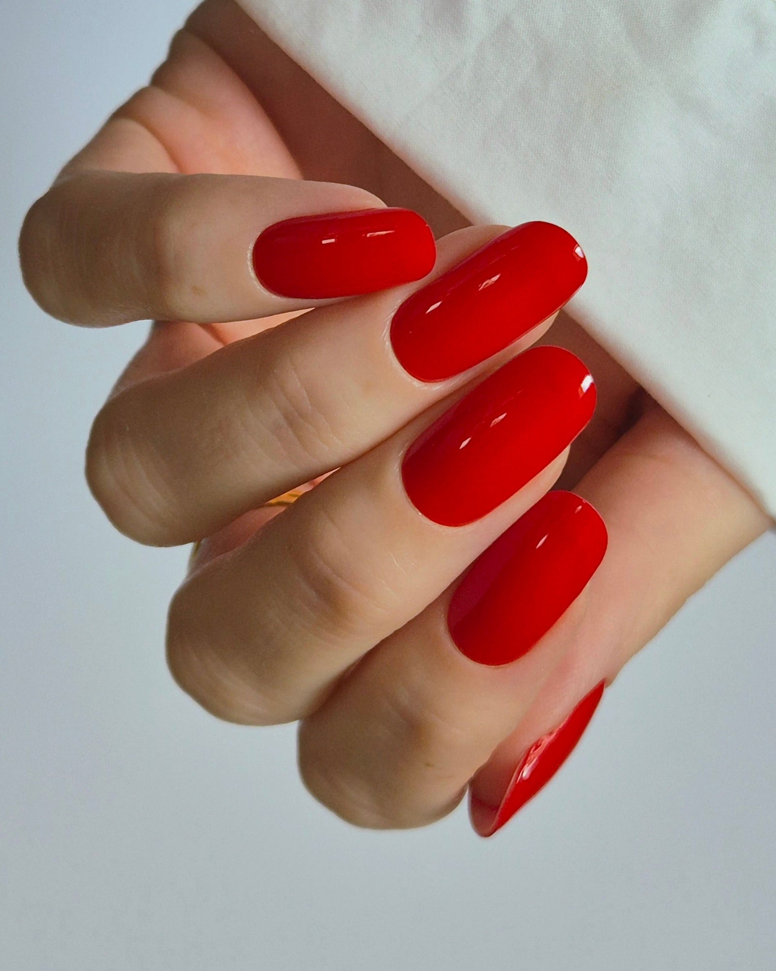 Hand mit leuchtend roten Nägeln trägt die Sheesh Nails UV-Nagelfolie „Lifeguard“. Der kräftige, hochglänzende Rotton sorgt für einen ausdrucksstarken, klassischen Look – perfekt für selbstbewusste Styles, Sommer-Outfits und elegante Auftritte.