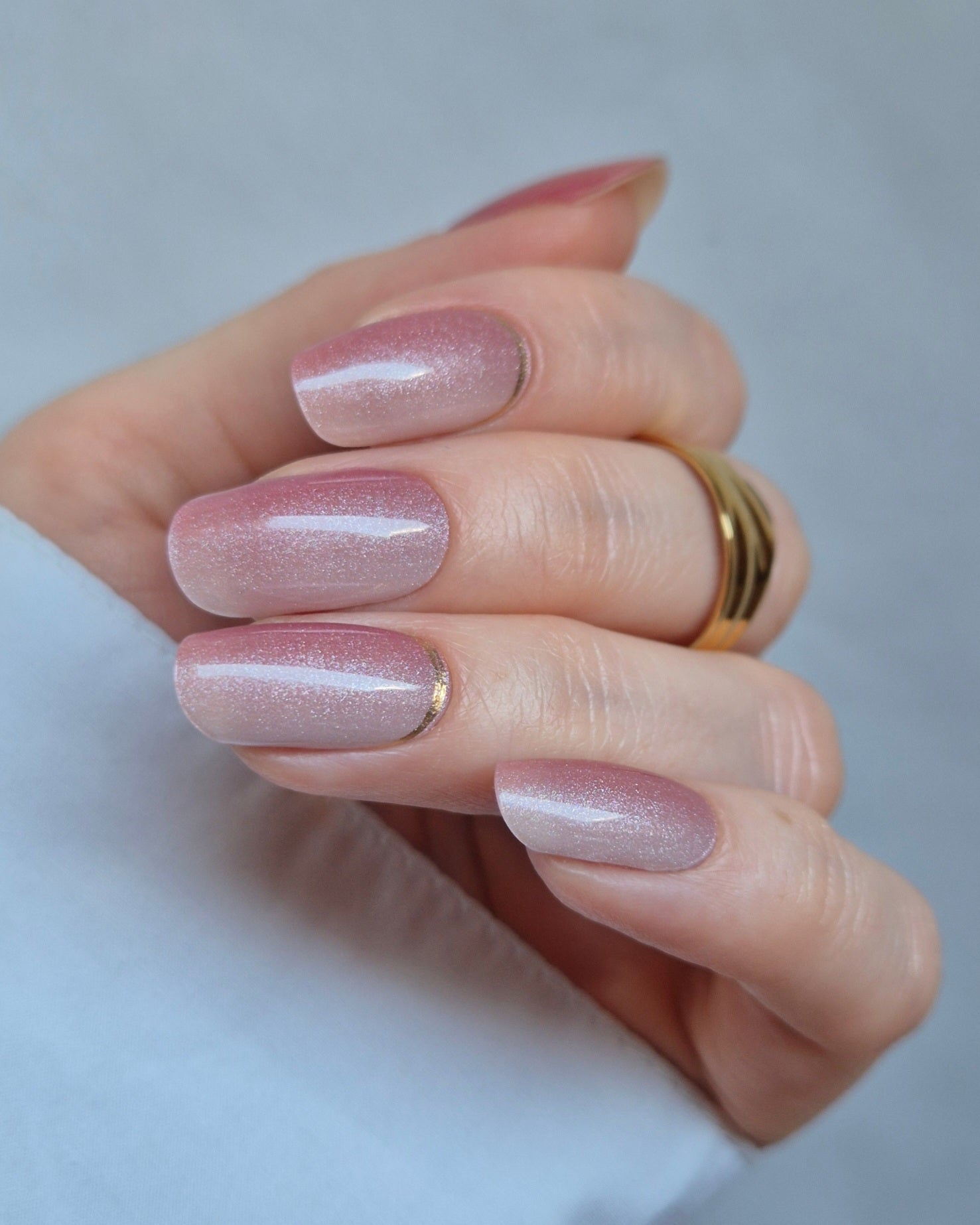 Nahaufnahme einer Hand mit der Sheesh Nails UV-Nagelfolie Little Secret. Die Nägel glänzen in einem sanften Rosé mit feinem, schimmerndem Silberverlauf und elegantem Finish. Der Look wirkt feminin, edel und modern – perfekt für Alltag, Date-Night oder besondere Anlässe.
