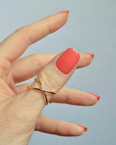 Hand mit korallroter UV-Maniküre von SHEESH Nails – „Lobster Roll“. Glänzende, gleichmäßig aufgetragene Gel-Nagelfolien in intensivem Korallton. Vegane, selbstklebende und lang haltbare Maniküre für ein sommerlich frisches Nail-Design zuhause.