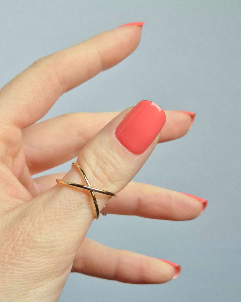 UV Nagelfolien in leuchtendem Korallrot – SHEESH Nails „Lobster Roll“. Hand hält glänzende korallrote Gel-Nagelfolien auf transparenter Trägerfolie. Intensive Sommerfarbe, vegan, selbstklebend und lang haltbar für perfekte Maniküre zuhause.