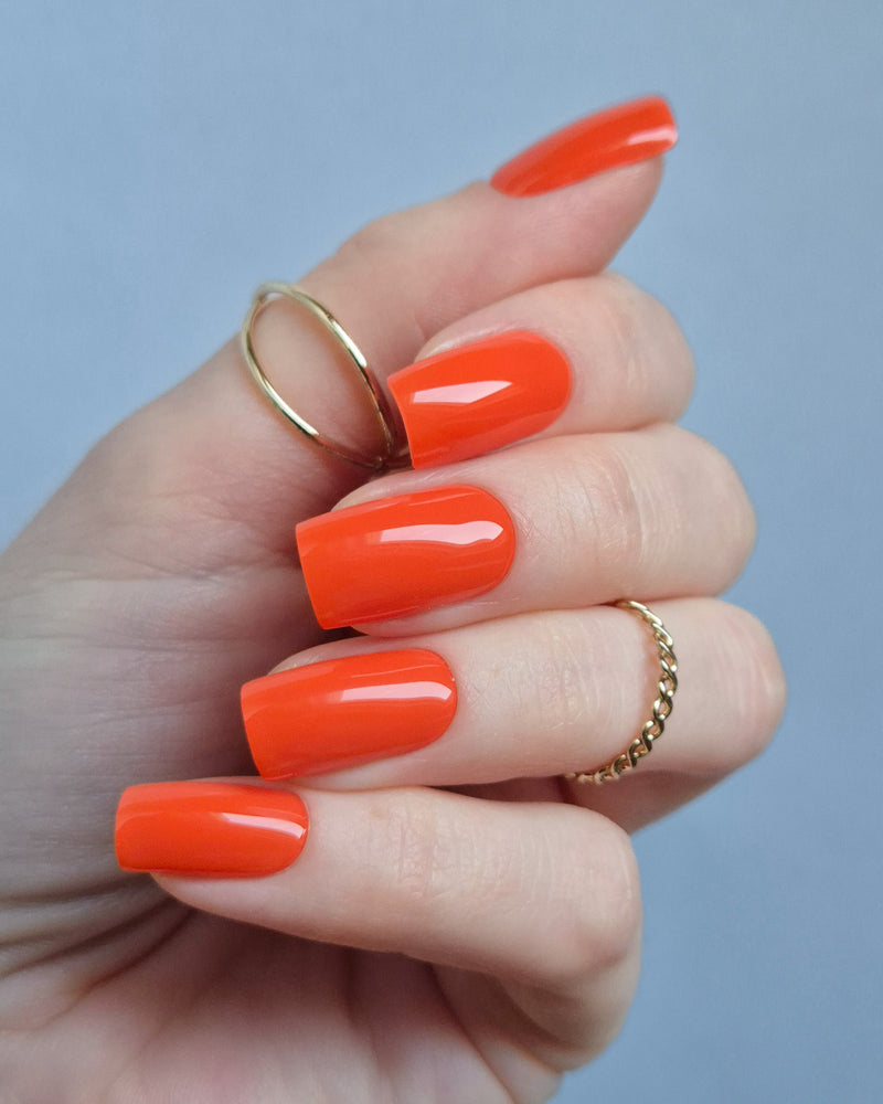 Leuchtend orange-rote UV-Nagelfolien mit glänzendem Finish auf Fingernägeln