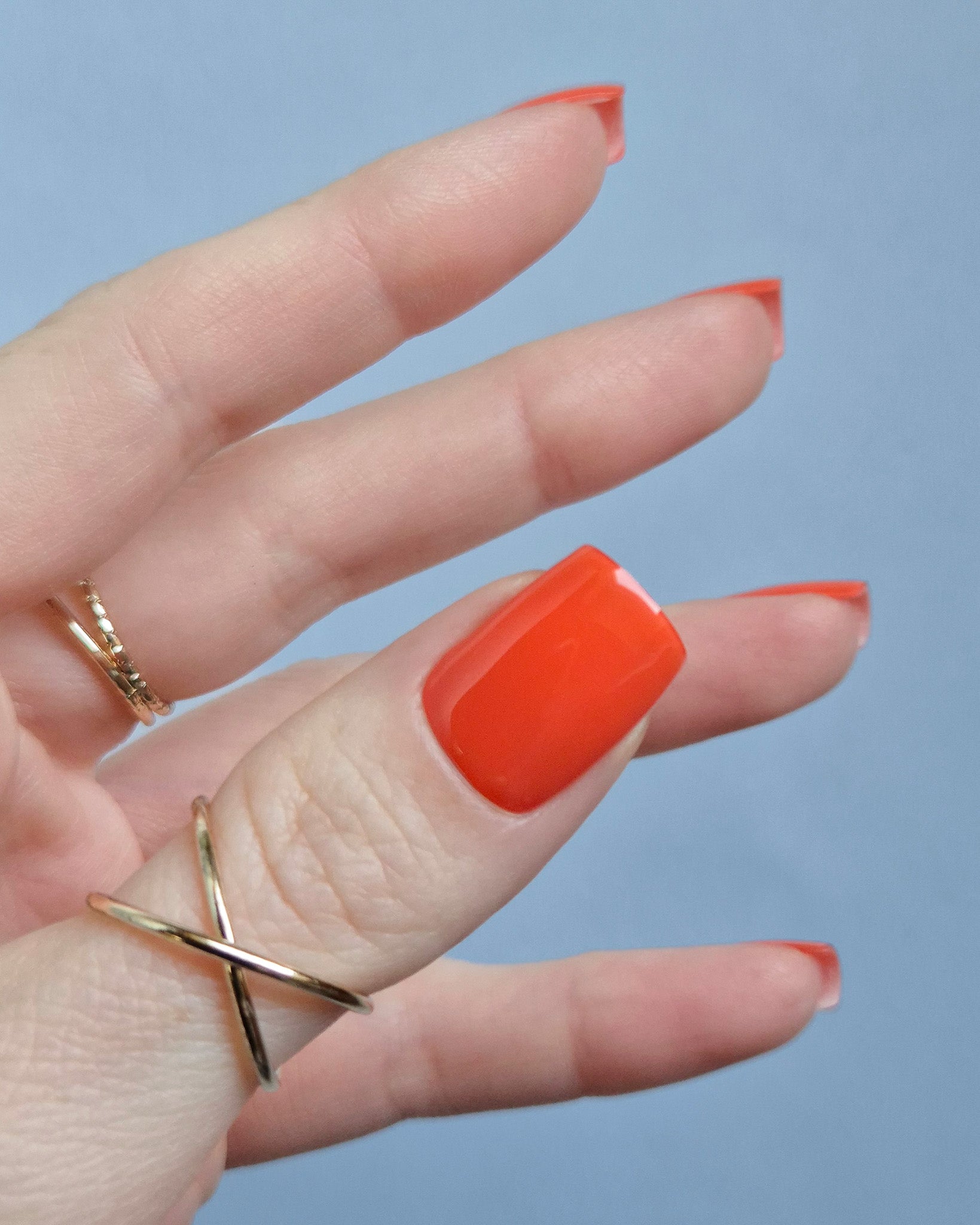 Leuchtend orange-rote UV-Nagelfolien mit glänzendem Finish auf Fingernägeln