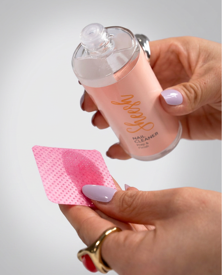 Sheesh Nails Nail Cleaner „Prep & Finish“ – klarer Nagelreiniger in transparenter 100-ml-Flasche mit weißem Deckel, Produktfoto auf roséfarbenem Hintergrund