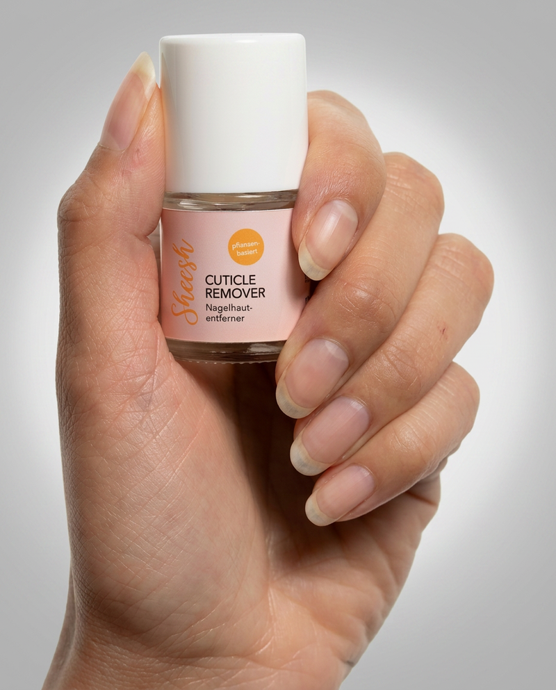 Sheesh Nails Cuticle Remover Nagelhautentferner im Glasfläschchen, in der Hand gehalten, pflanzenbasiert zur Nagelhautpflege.