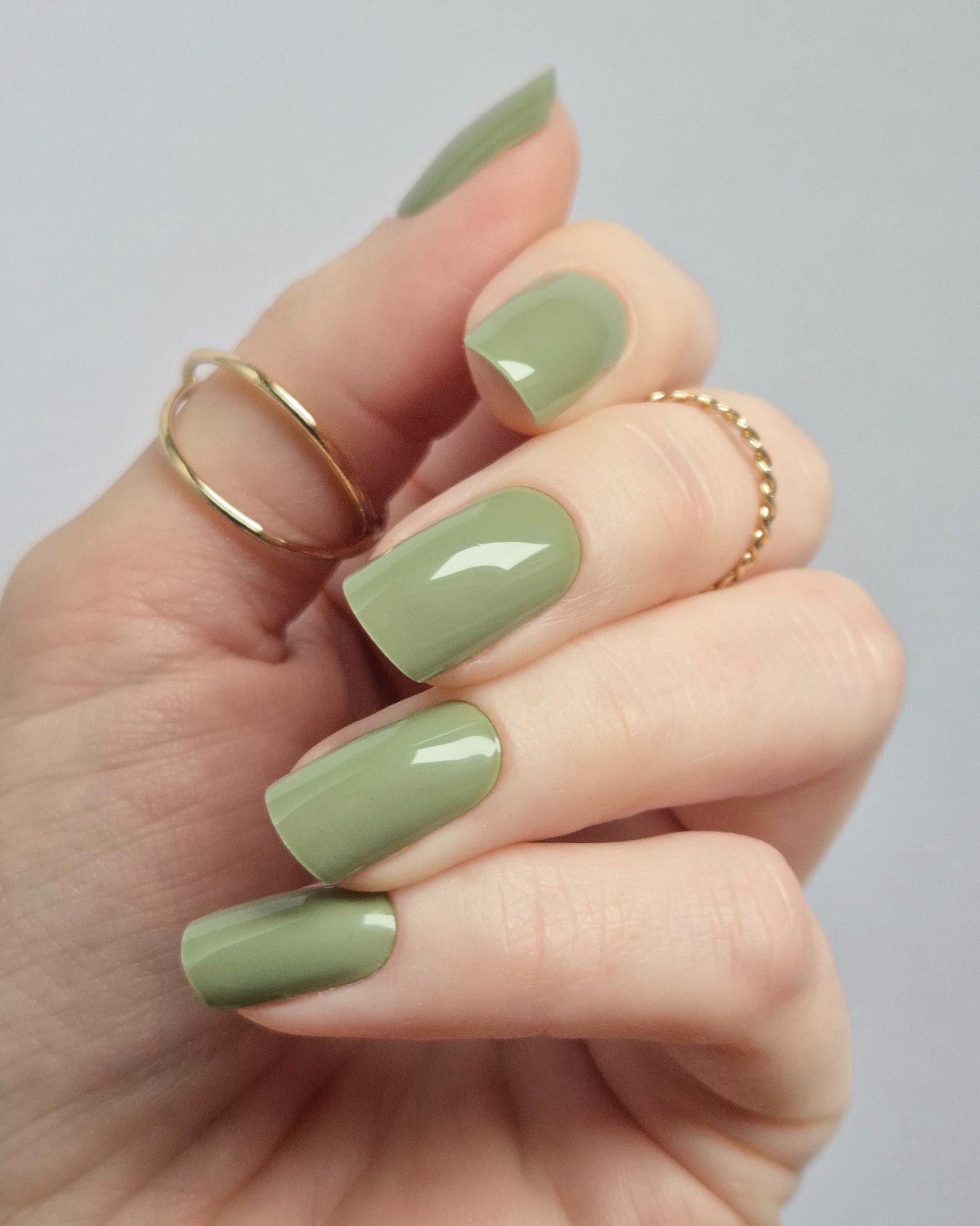 Olivgrüne UV-Nagelfolien mit glänzendem Finish auf langen Fingernägeln