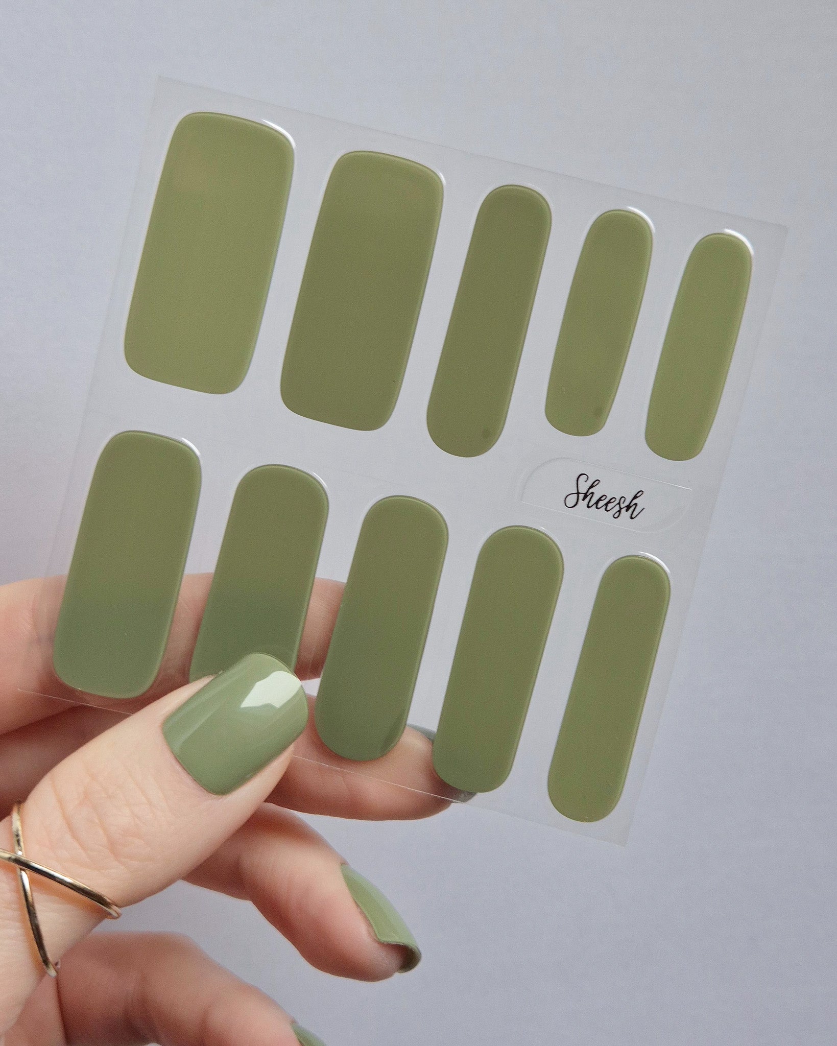 Olivgrüne UV-Nagelfolien mit glänzendem Finish auf langen Fingernägeln