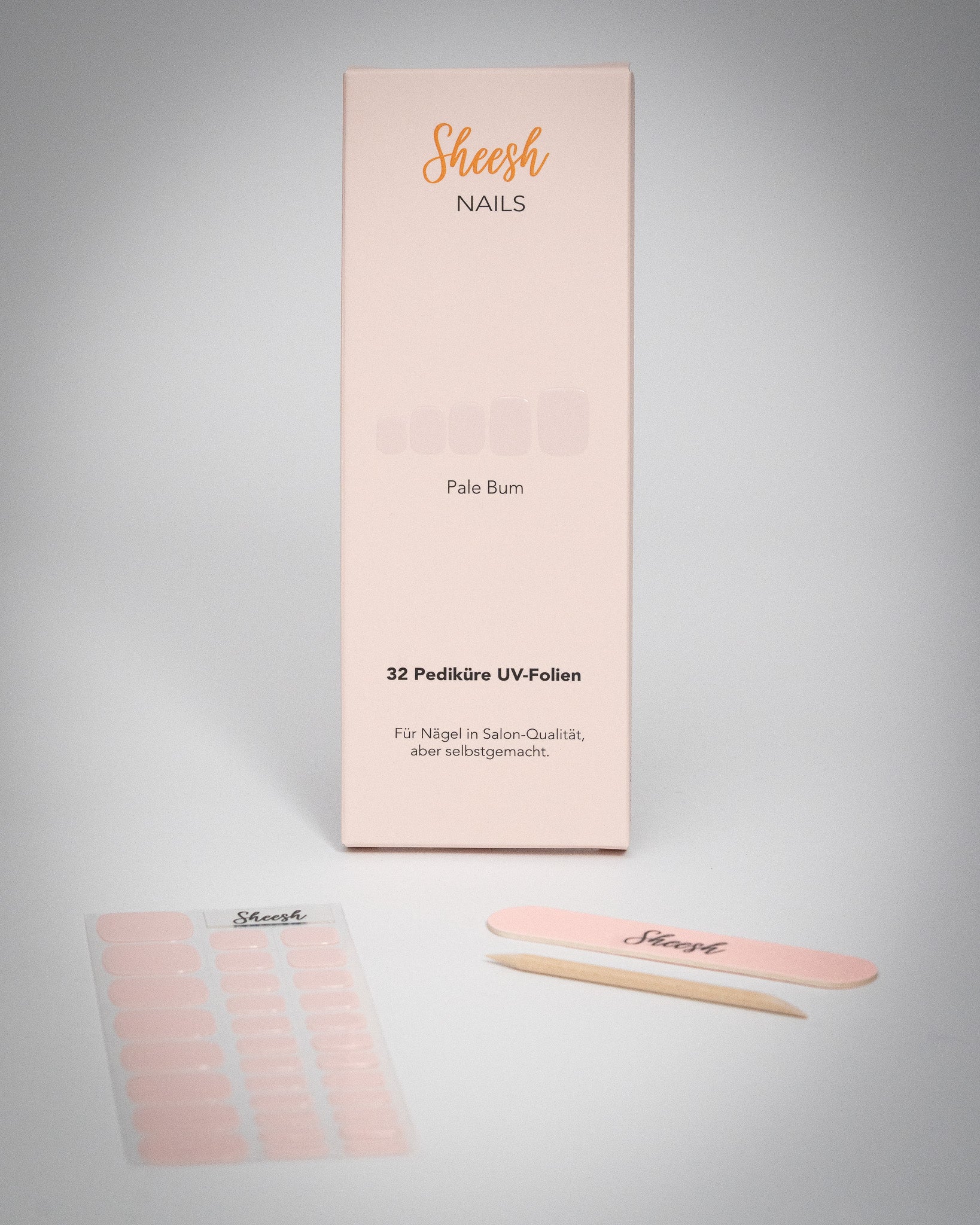 Sheesh Nails Pediküre UV-Folien „Pale Bum“ in zartem Rosé. Verpackung mit 32 UV-Folien, Nagelfeile und Holzstäbchen auf weißem Hintergrund. Für eine elegante Pediküre in Salon-Qualität – einfach selbstgemacht mit UV-Lampe.