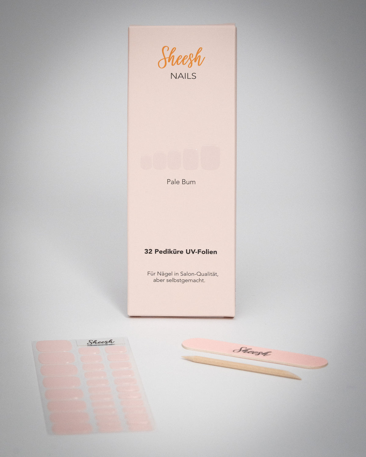 Sheesh Nails Pediküre UV-Folien „Pale Bum“ in zartem Rosé. Verpackung mit 32 UV-Folien, Nagelfeile und Holzstäbchen auf weißem Hintergrund. Für eine elegante Pediküre in Salon-Qualität – einfach selbstgemacht mit UV-Lampe.
