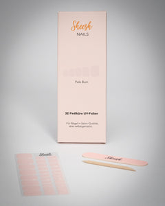 Sheesh Nails Pediküre UV-Folien „Pale Bum“ in zartem Rosé. Verpackung mit 32 UV-Folien, Nagelfeile und Holzstäbchen auf weißem Hintergrund. Für eine elegante Pediküre in Salon-Qualität – einfach selbstgemacht mit UV-Lampe.