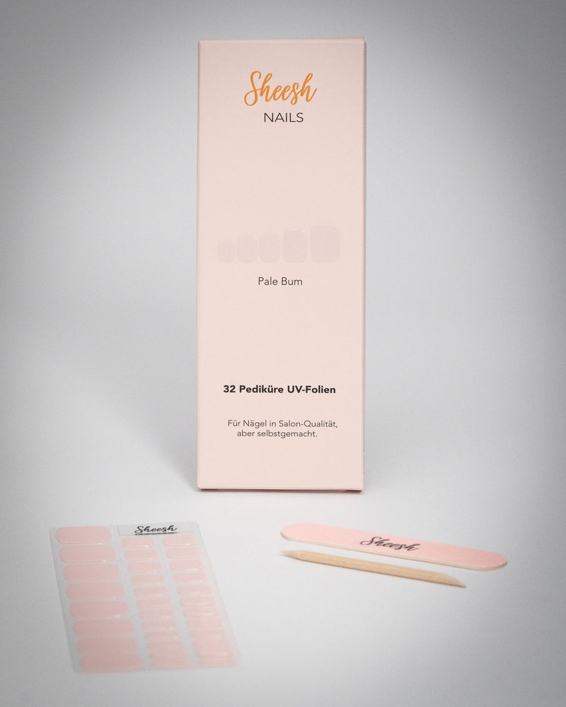 Sheesh Nails Pediküre UV-Folien „Pale Bum“ in zartem Rosé. Verpackung mit 32 UV-Folien, Nagelfeile und Holzstäbchen auf weißem Hintergrund. Für eine elegante Pediküre in Salon-Qualität – einfach selbstgemacht mit UV-Lampe.