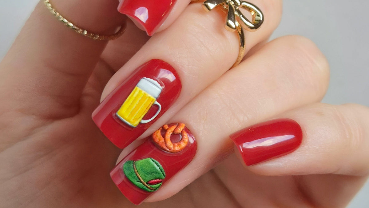 Sheesh Nails Wiesen-Sticker – rote Maniküre mit 3D-Nagelstickern in Oktoberfest-Motiven wie Brezn, Maßkrug und Trachtenhut, festliche Nailart für Wiesn-Looks und kreative Nageldesigns.