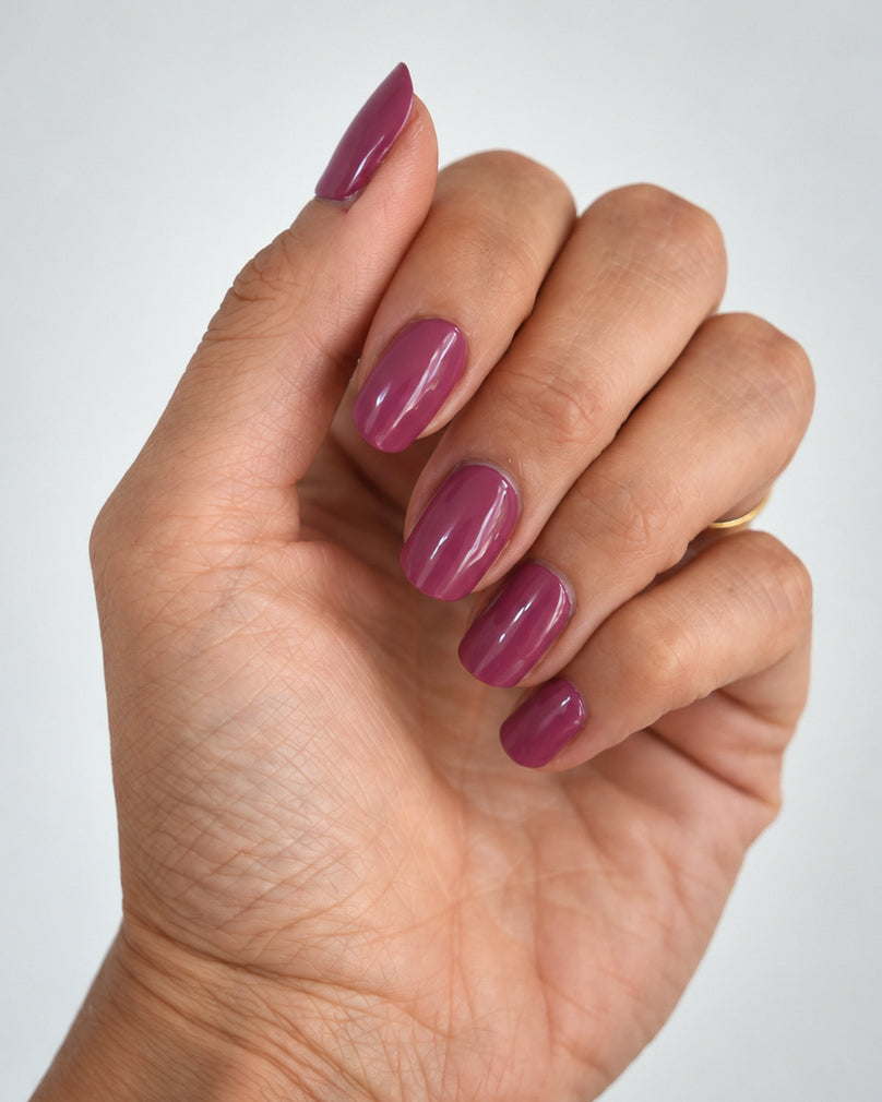 Glänzende Sunset Pink UV-Nagelfolien von SHEESH Nails in Beerenpink auf oval geformten Nägeln.
