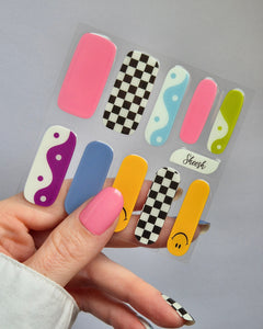 Sheesh Nails – Tip Tok – bunte Nagelfolien im Retro-Design mit fröhlichen Smileys, Karomuster und sanften Blautönen. Perfekte Passform und starker Halt für kreative, verspielte Maniküren im Trendstil der 2000er.