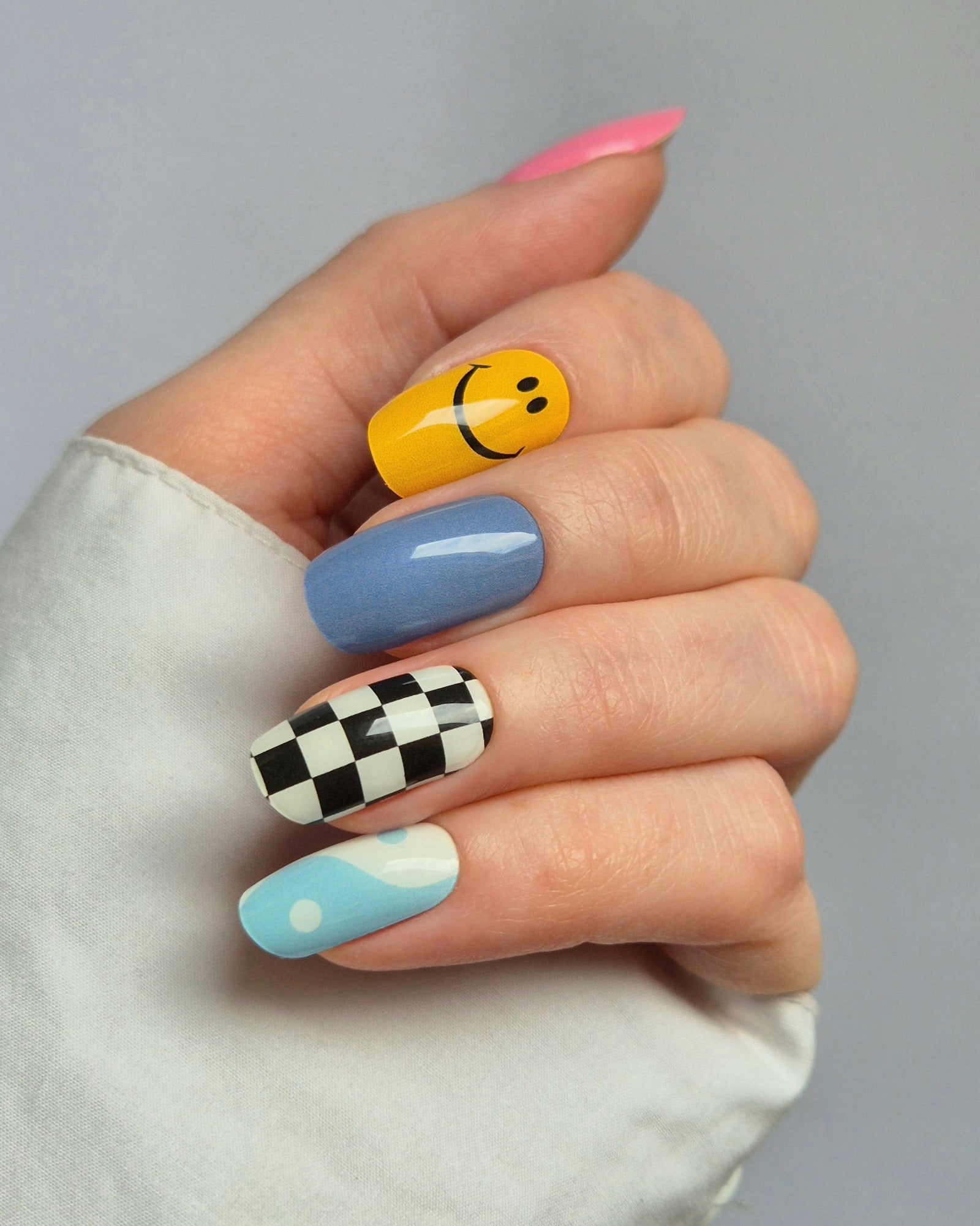 Sheesh Nails – Tip Tok – bunte Nagelfolien im Retro-Design mit fröhlichen Smileys, Karomuster und sanften Blautönen. Perfekte Passform und starker Halt für kreative, verspielte Maniküren im Trendstil der 2000er.