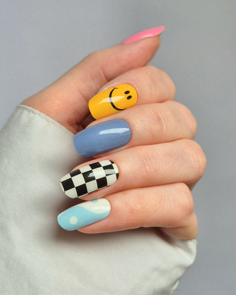 Sheesh Nails – Tip Tok – bunte Nagelfolien im Retro-Design mit fröhlichen Smileys, Karomuster und sanften Blautönen. Perfekte Passform und starker Halt für kreative, verspielte Maniküren im Trendstil der 2000er.