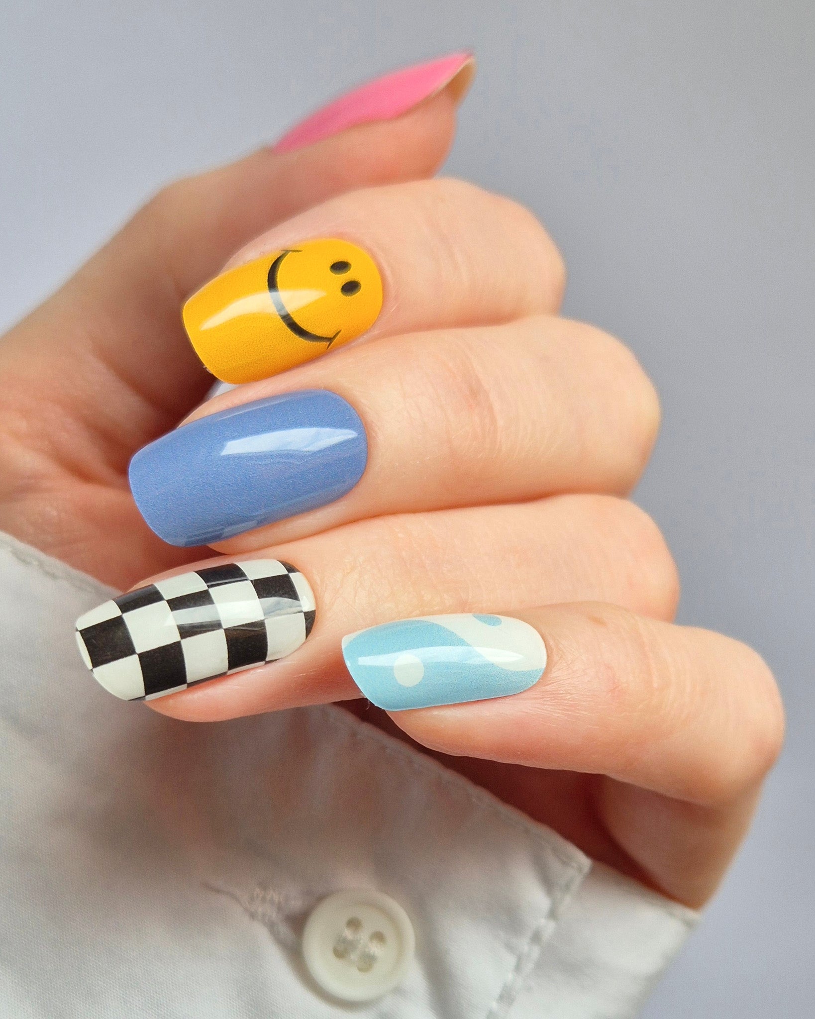 Sheesh Nails – Tip Tok – bunte Nagelfolien im Retro-Design mit fröhlichen Smileys, Karomuster und sanften Blautönen. Perfekte Passform und starker Halt für kreative, verspielte Maniküren im Trendstil der 2000er.