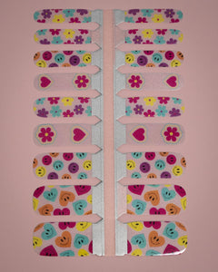 SHEESH Nails – Big Smile, Bild 05: Kinder-Nagelfolie Big Smile mit farbenfrohen Blumen-, Herz- und Smiley-Designs in geöffneter Folienverpackung.