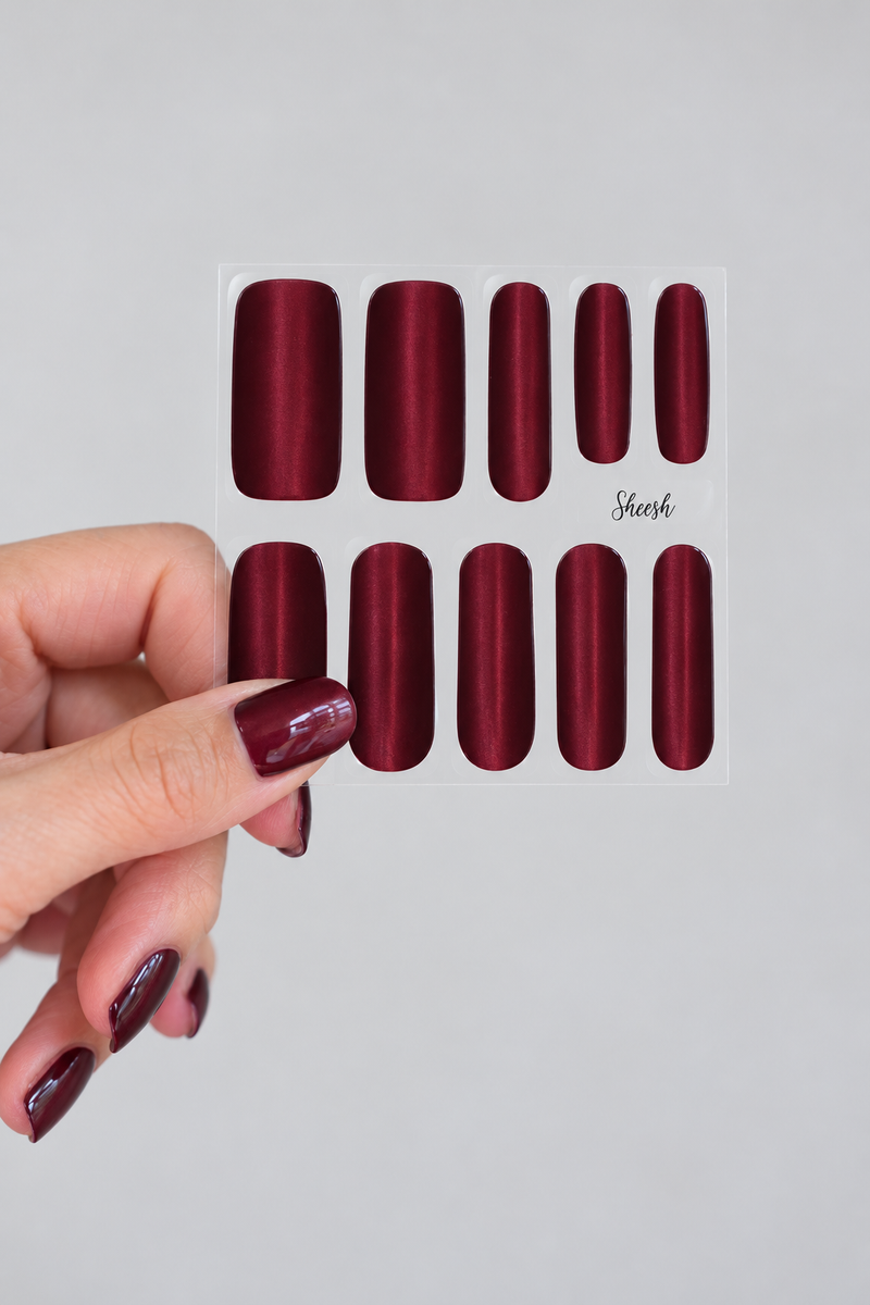SHEESH Nails – Cat Eye UV-Nagelfolien in Bordeauxrot mit schimmerndem Cat-Eye-Effekt auf dem Folienbogen.