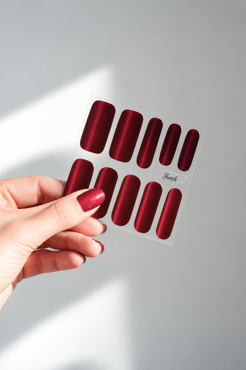 SHEESH Nails – Cat Eye Folienbogen mit rotem Cat-Eye-Schimmer im Sonnenlicht.