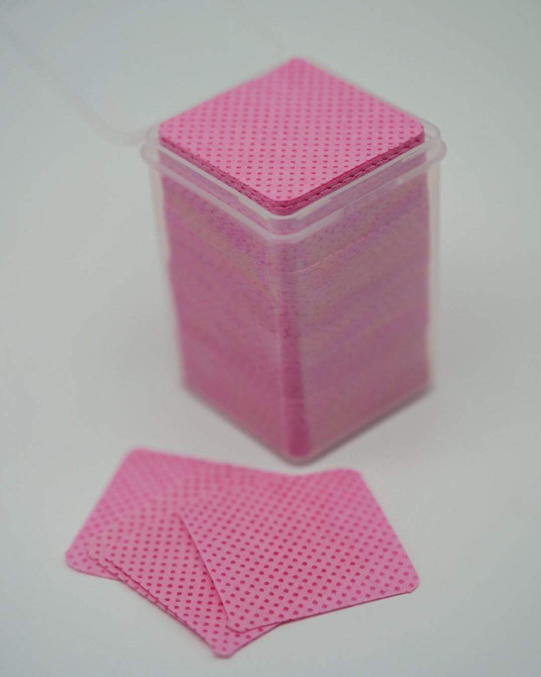 Produktaufnahme der Sheesh Nails Fussel- und staubfreien Zellstoff-Pads in zartem Rosa. Die Pads sind ordentlich in einer transparenten Box gestapelt und zeigen ihre fein strukturierte Oberfläche. Sie eignen sich ideal zur gründlichen Reinigung und Vorbereitung der Nägel vor dem Auftragen der UV-Nagelfolien. Das hochwertige, fusselfreie Zellstoffmaterial sorgt für eine hygienische Anwendung und ein perfektes, professionelles Ergebnis bei jeder Maniküre oder Pediküre.