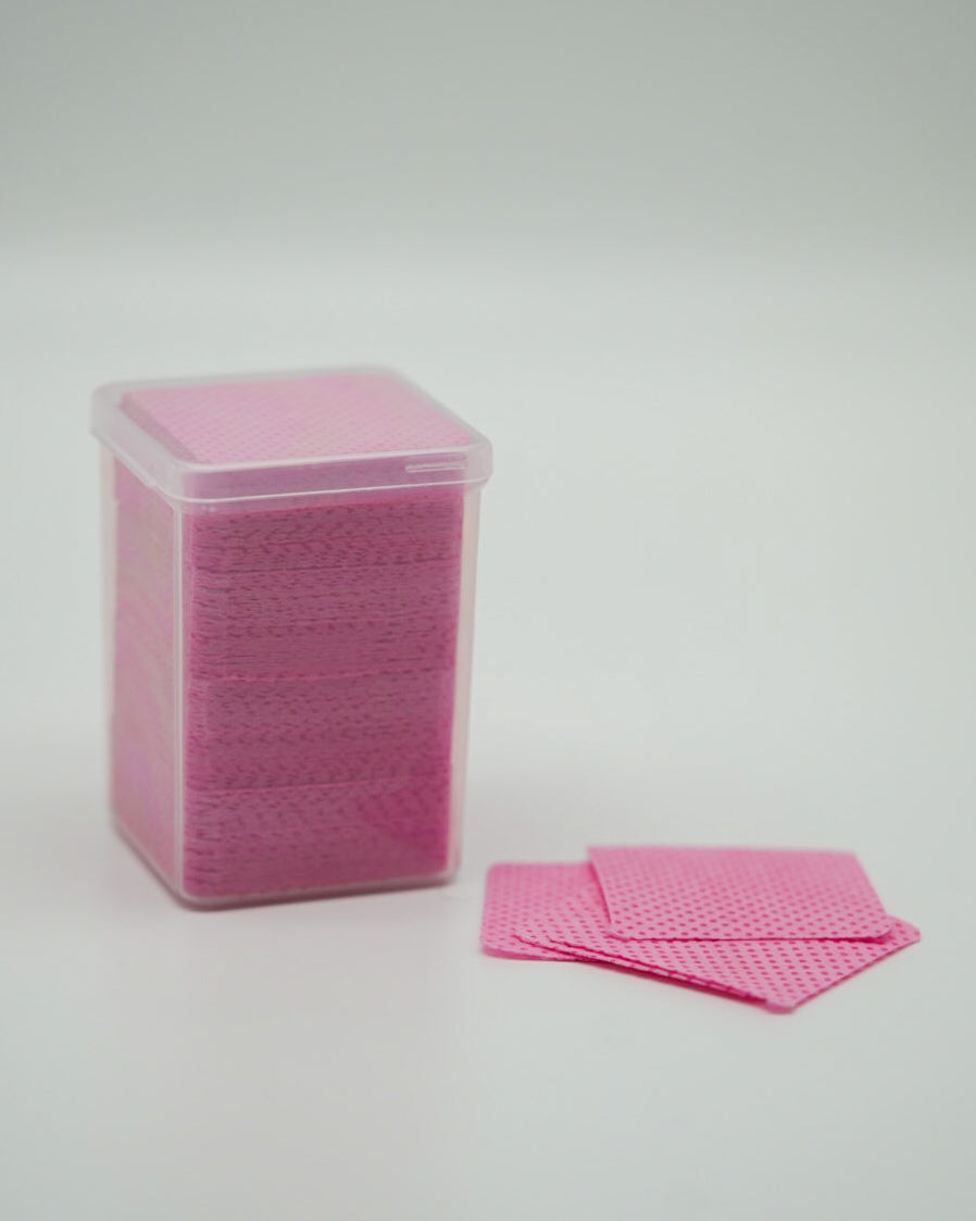 Produktaufnahme der Sheesh Nails Fussel- und staubfreien Zellstoff-Pads in zartem Rosa. Die Pads sind ordentlich in einer transparenten Box gestapelt und zeigen ihre fein strukturierte Oberfläche. Sie eignen sich ideal zur gründlichen Reinigung und Vorbereitung der Nägel vor dem Auftragen der UV-Nagelfolien. Das hochwertige, fusselfreie Zellstoffmaterial sorgt für eine hygienische Anwendung und ein perfektes, professionelles Ergebnis bei jeder Maniküre oder Pediküre.